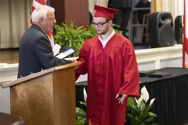 A 2023 graduate from Helen Keller School of Alabama accepts a Board of Trustee Leadership Scholarship.